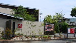 山梨県昭和町のお蕎麦屋「奥京」の外構リノベーション施工例。雑木と割栗石が調和した、和モダンで品格のある店舗エントランス。