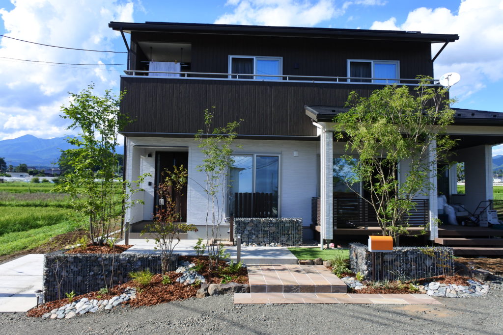 山梨県北杜市の外構施工例。ガビオンの門柱と雑木の植栽が調和した、北杜市の自然に馴染むナチュラルなオープン外構。