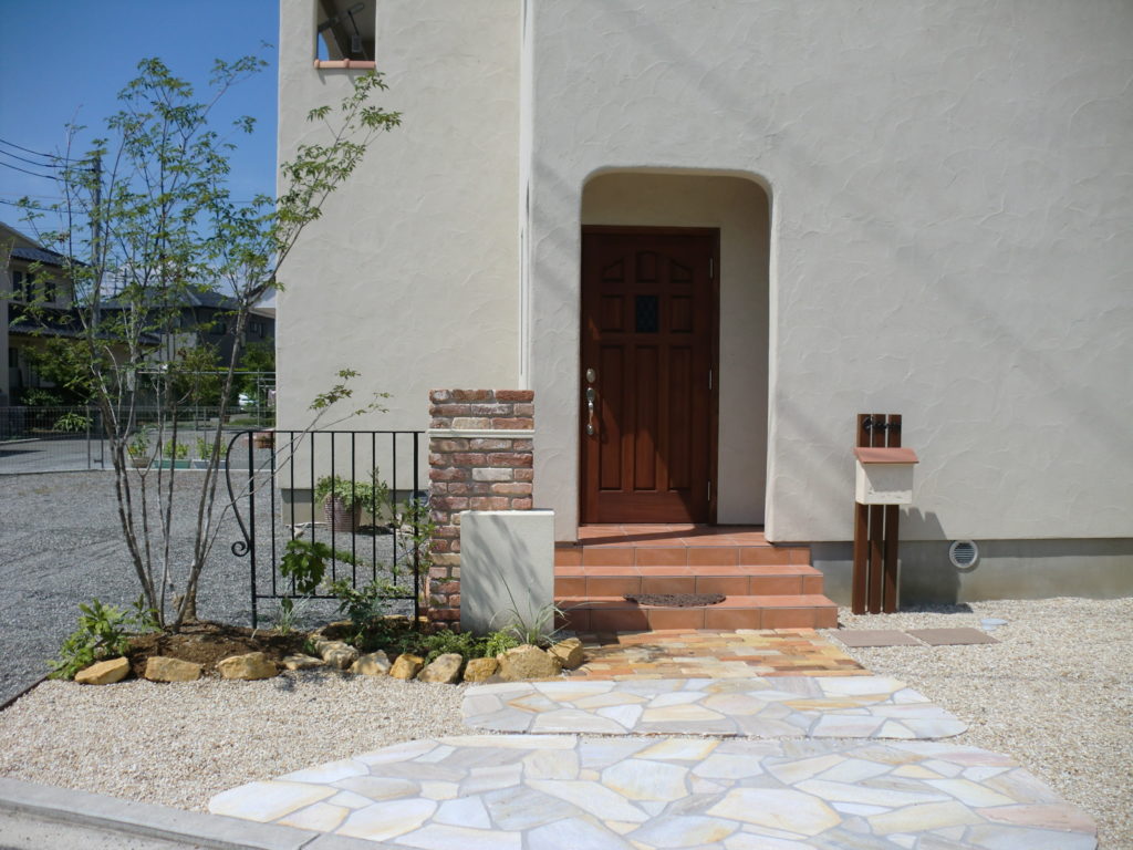 山梨県甲府市の外構施工例。ディーズガーデンのポストやアンティークレンガ、ロートアイアンの装飾が可愛い南欧風のオープン外構。