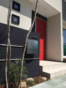 深紫の門柱にシンプルなデザインのポスト