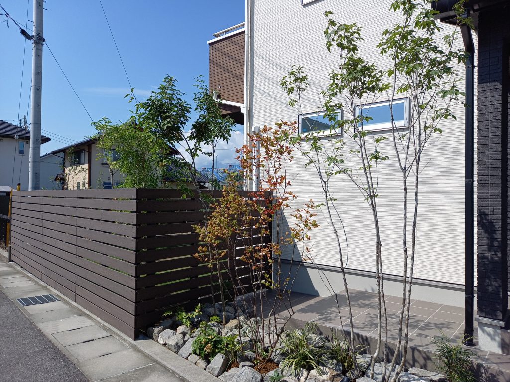 玄関前には最近の外構ではよく取り入れられているアオダモなど雑木系の樹木を。 玄関の横の植栽スペースなので樹木が近くともスッキリとした印象を出したいと思い選びました。