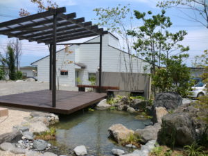 山梨県増穂町（富士川町）の外構施工例。池のある庭とウッドデッキテラス、雑木が調和したリゾートライクなナチュラルガーデン。