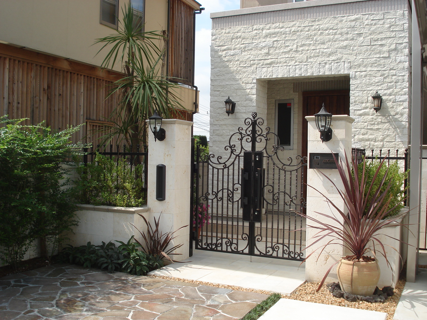 山梨県甲府市の高級外構施工例。ロートアイアンの門扉と意匠壁で構成された、エレガントなヨーロピアン調のクローズ外構。