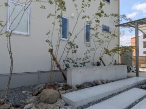 山梨県甲斐市の外構施工例。ローウォールと雑木の庭、割栗石を組み合わせた開放感のあるモダンナチュラルなエントランス。