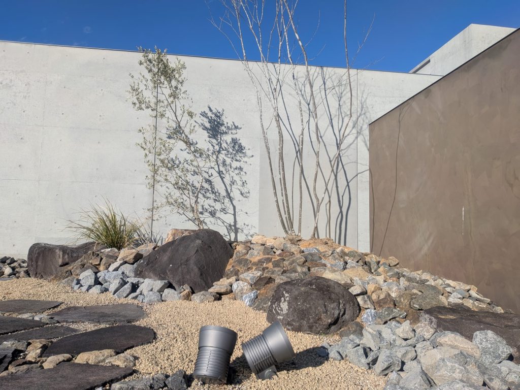 打ち放しのコンクリート壁と、無骨な石のテクスチャ